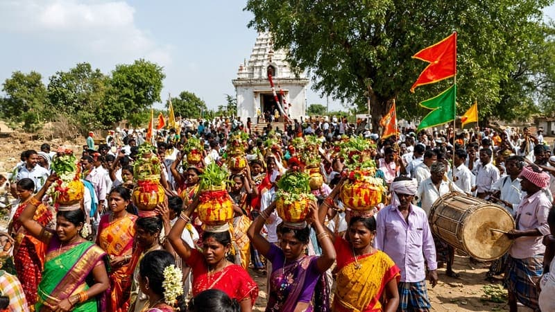 Crowd in colourful clothes carrying offerings in a village jatara procession